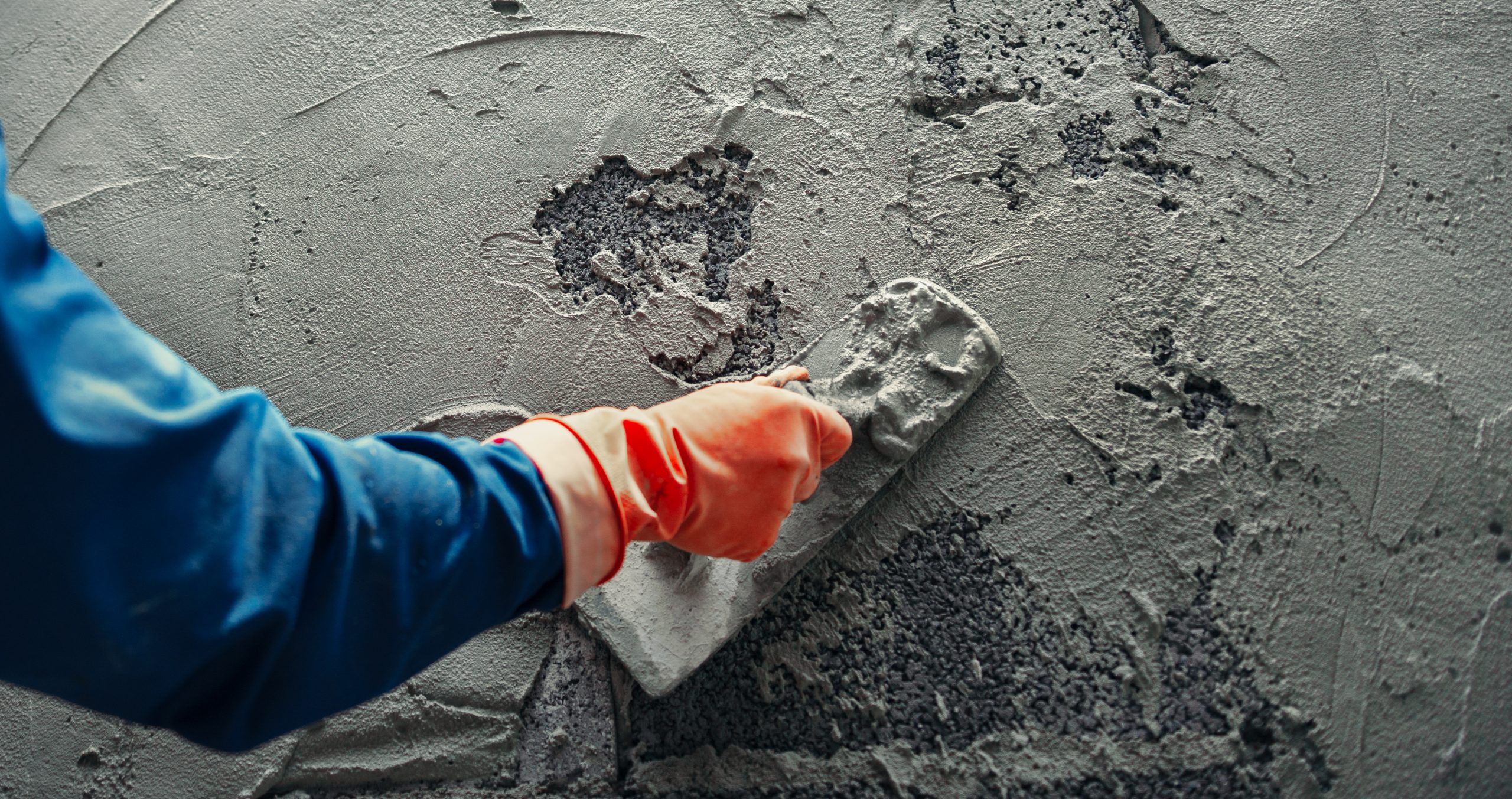 hand of worker plastering cement at wall for building house